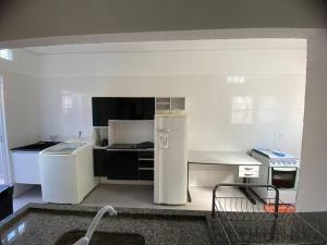 a small kitchen with a refrigerator and a stove at Residencial Málaga 02 in Sinop