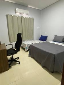 a bedroom with a bed and a chair and a desk at Residencial Málaga 02 in Sinop