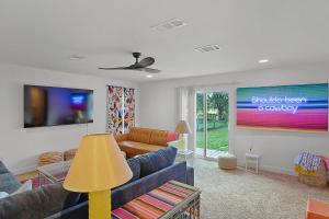 ein Wohnzimmer mit Sofa und Fernseher in der Unterkunft LaTexienda - 7min to A&M - Firepit - Volleyball - BBQ in College Station