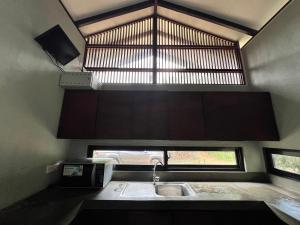 Una pequeña cocina con fregadero y ventana. en Willow's Abode, en Kandy