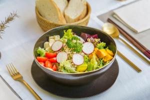 a bowl of vegetables on a table with a bowl of bread at Viroth's Hotel in Siem Reap