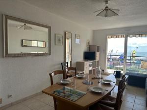 ein Esszimmer mit Tisch und Blick auf das Meer in der Unterkunft Notre-Dame-de-Monts (85) - Appartement de vacances 45m² environ - 4 personnes - FR-1-540-294 in Notre-Dame-de-Monts