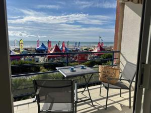 einen Balkon mit einem Tisch und Stühlen sowie Strandblick in der Unterkunft Notre-Dame-de-Monts (85) - Appartement de vacances 45m² environ - 4 personnes - FR-1-540-294 in Notre-Dame-de-Monts