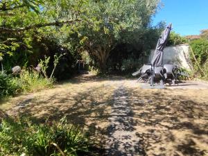 a sculpture of an umbrella on the side of a dirt road at Maison familiale 10 pers avec jardin et parking à Saint-Georges d'Oléron - FR-1-778-31 in Saint-Georges-dʼOléron