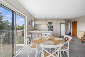 een keuken en eetkamer met een tafel en stoelen bij Modern 2-Bedroom Oasis Just Steps from the Beach in Christchurch +10 foto's