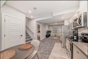 a kitchen and dining room with a table and appliances at Cozy Basement Suite in Calgary +8 photos