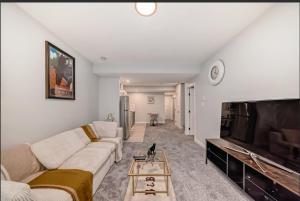 a living room with a couch and a flat screen tv at Cozy Basement Suite in Calgary