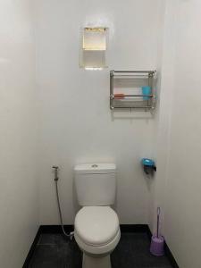 a bathroom with a white toilet in a room at Free Breakfast Kabayod Place A1, General Luna Siargao in General Luna