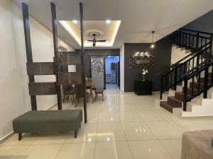 a living room and dining room with a table and stairs at D’Lora Homestay in Malacca