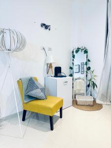 ein Wohnzimmer mit einem gelben Stuhl und einem Spiegel in der Unterkunft Monoambiente completo, amplio y céntrico in Santa Cruz de la Sierra + 4 Fotos