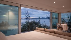 a bedroom with a bed and a view of the water at Seascapes Waterfront 3 in Paraparaumu