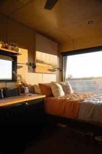 巴瑟尔顿Alisa the Tiny Cabin in Busselton的一间带床和大窗户的卧室