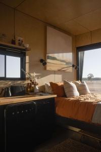 巴瑟尔顿Alisa the Tiny Cabin in Busselton的一间带床的卧室和一间带水槽的厨房