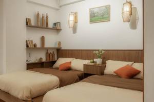 ハノイにあるHanoi Canvas Homee in Hoan Kiemのベッド2台と棚が備わる部屋
