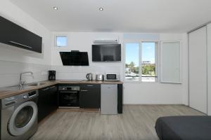 eine Küche mit Spüle und Waschmaschine in der Unterkunft Ocean House in Noumea