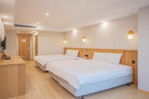 a hotel room with two beds and a television at Hamilton Hotel in Taichung