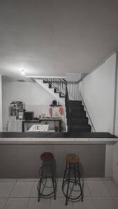two stools at a counter in a room with a staircase at Conscioushouse 3BR near Seminyak up to 10pax in Legian