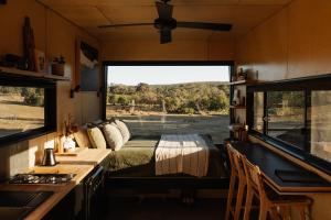亚林加普Chrissy the Tiny Cabin in Yallingup的一间卧室,配有一张床和一个火车上的窗口