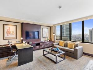 a living room with a couch and a tv at Mandarin Oriental, Jakarta in Jakarta