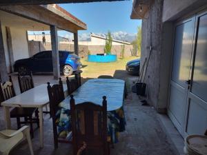 Una mesa y sillas en un patio con un coche. en Rinconcito Don Antonio, en Tinogasta
