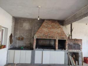 Una cocina con una pared de ladrillo y una chimenea. en Rinconcito Don Antonio, en Tinogasta 2 fotos más