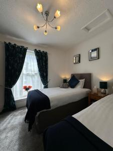 a bedroom with two beds and a window at Abbey House B & B in Penrith