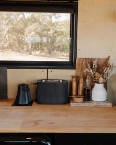 Un mostrador de cocina con una ventana y un mostrador con flores. en Bon the Tiny Cabin in Yallingup, en Yallingup
