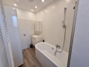 a white bathroom with a tub and a sink at Süße Marie 9 in Karlsruhe