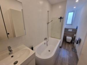 a bathroom with a tub and a sink and a bath tub at Süße Marie 9 in Karlsruhe