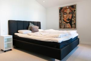 un grande letto in una stanza con un dipinto sul muro di Strandhuset. ad Asperup