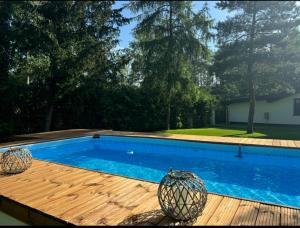 a swimming pool on a wooden deck with a blue pool at Zakątek nad Wkrą in Goławice