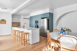 une cuisine avec une table, des chaises et un réfrigérateur dans l'établissement Pacific Paradise - 4 Bedroom House Central Coast, à Long Jetty