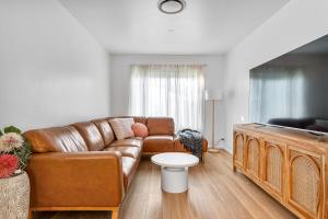 - un salon avec un canapé en cuir brun dans l'établissement Pacific Paradise - 4 Bedroom House Central Coast, à Long Jetty