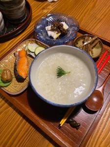 a bowl of soup on a wooden tray with chopsticks at 小浜島カーリー商會 in Taketomi