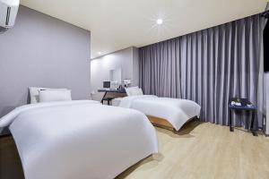 a hotel room with two beds and a window at Icheon Paradise Hotel in Saebaem-gol