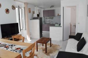 a living room with a couch and a table at Le Bangorcoo'n F3 Liouba in Forges