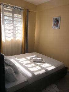 a bed with a towel on it in a bedroom at Kisumu Airview Homestay in Kisumu