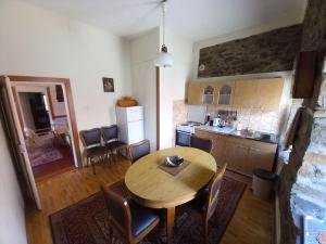 a kitchen and dining room with a wooden table and chairs at **ETNO Vila** - KRUSEVO in Kruševo