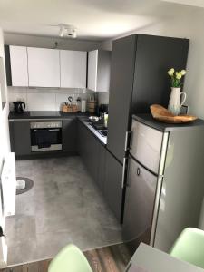 a kitchen with black and white cabinets and a refrigerator at IaM Attendorn 4 Betten 60 Qm Neu Modernisiert in Attendorn