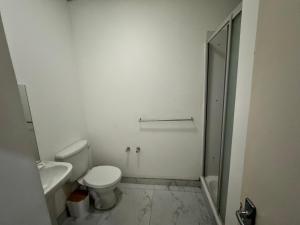 Un baño blanco con inodoro y ducha. en Colosseum Apartments, en Johannesburgo 18 fotos más