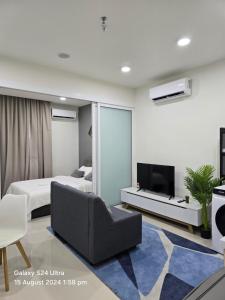 a bedroom with a bed and a couch and a tv at The Shore SeaView Center Kota Kinabalu Home Suites Studio in Kota Kinabalu