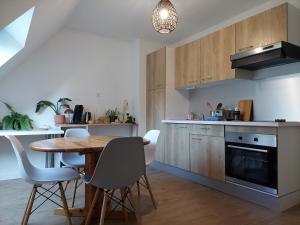 cocina con mesa de madera y sillas y comedor en Le 105 - appart-sympa - T2 vue jardin et cave - Larmor-Plage, en Larmor-Plage
