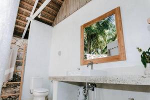 a bathroom with a sink and a mirror at Rote White House - South Villa & Loft in Nembrala +43 photos