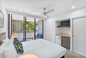 パーム・コーブにあるBowmanii at Temple Resort - Sunkissed Tropical Vibesのベッドルーム(白いベッド1台付)、キッチン