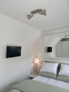 a bedroom with a bed and a lamp and a tv at Willow House, Georgian Property in Shepperton, Double-Bed with Living Room, Bathroom and Utility Room available in Shepperton