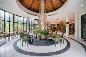ein Esszimmer mit Tischen und Stühlen und einem Kronleuchter in der Unterkunft At Rice Resort in Nakhon Nayok