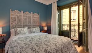 Un dormitorio con una cama grande y una ventana. en AbraCadabra Suites, en Madrid