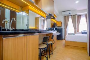a kitchen with a sink and a bed in a room at Comfort and Best Deal Studio Room Transpark Cibubur Apartment By Travelio in Depok