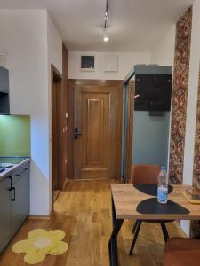 a living room with a table and a wooden door at Guest House Vila Lujza in Palić