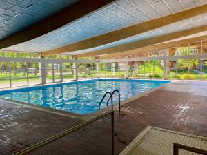 a large swimming pool with blue water in a building at Chalet des Moineaux in Saint-Laurent-en-Grandvaux
